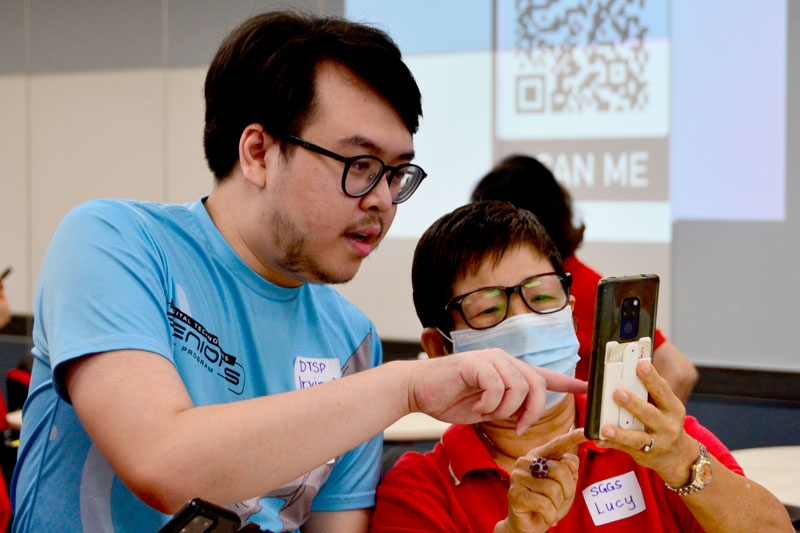 A Cyber Ambassador Irvin Jamesson James Ping (left) mentors one of the senior citizens from the Sarawak Gerontology and Geriatric Society (SGGS).