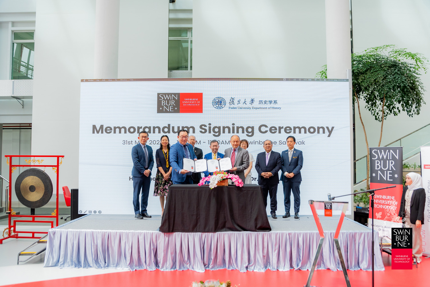 Professor Huang Yang (front row, right) and Ir Professor Lau Hieng Ho (front row, left) hold up the signed MoU as Deputy Premier of Sarawak YB Datuk Amar Professor Dr Sim Kui Hian (centre) and others look on. 